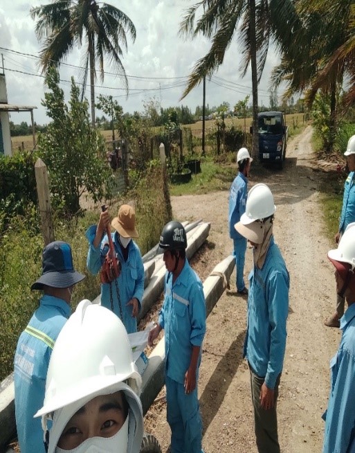 A group of people wearing helmets and standing on a dirt road